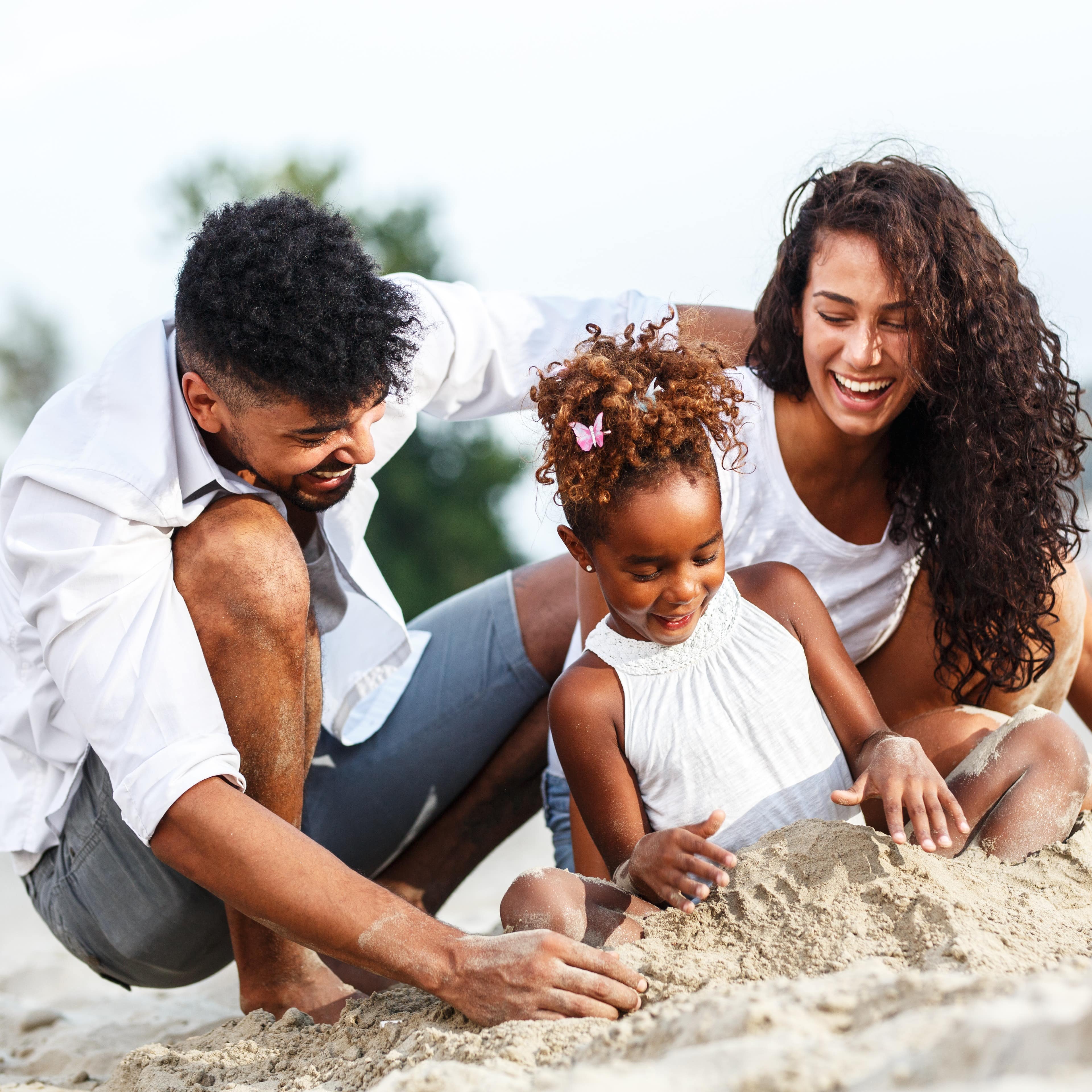 Young family playing in the sand on the beach