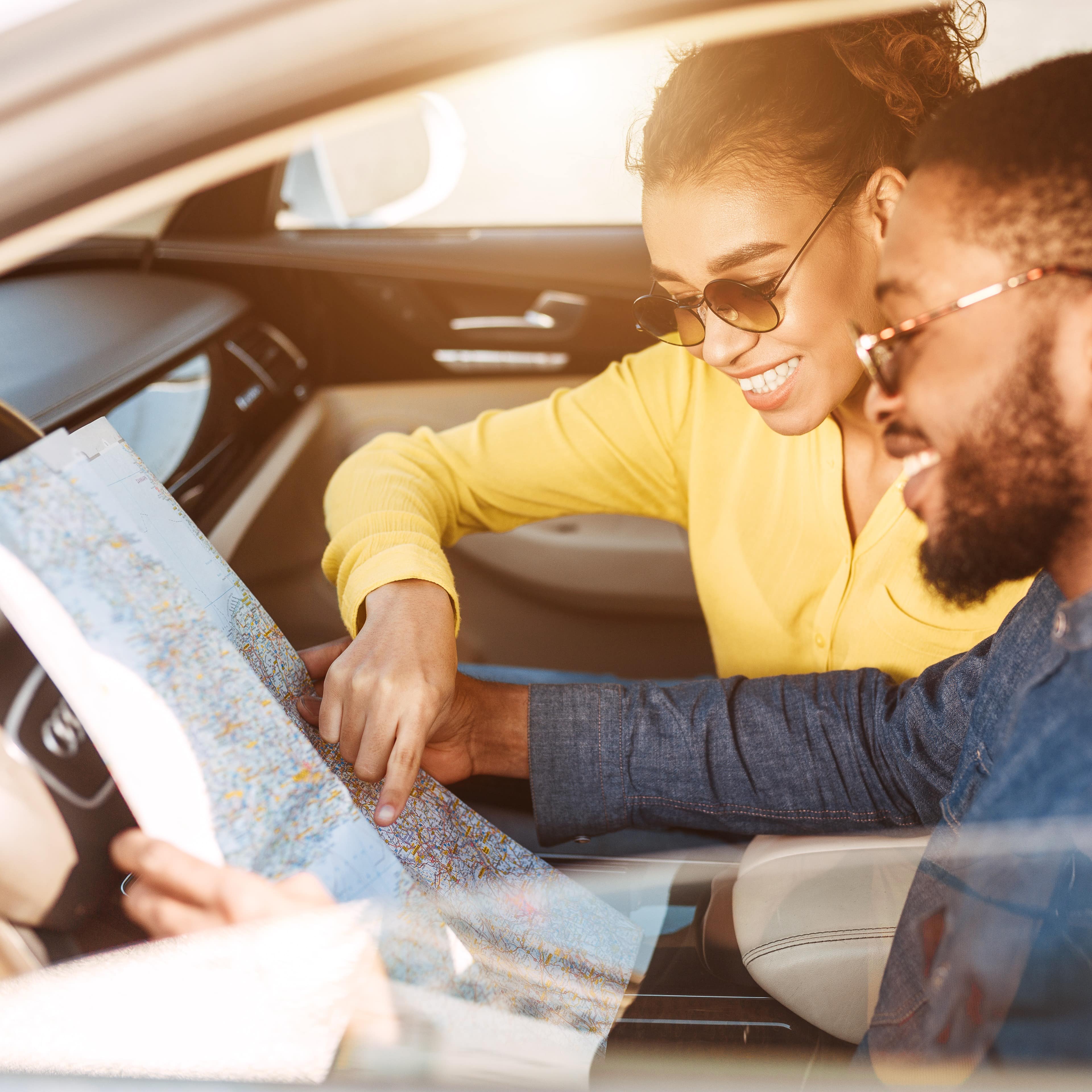 Couple sitting in car looking at map
