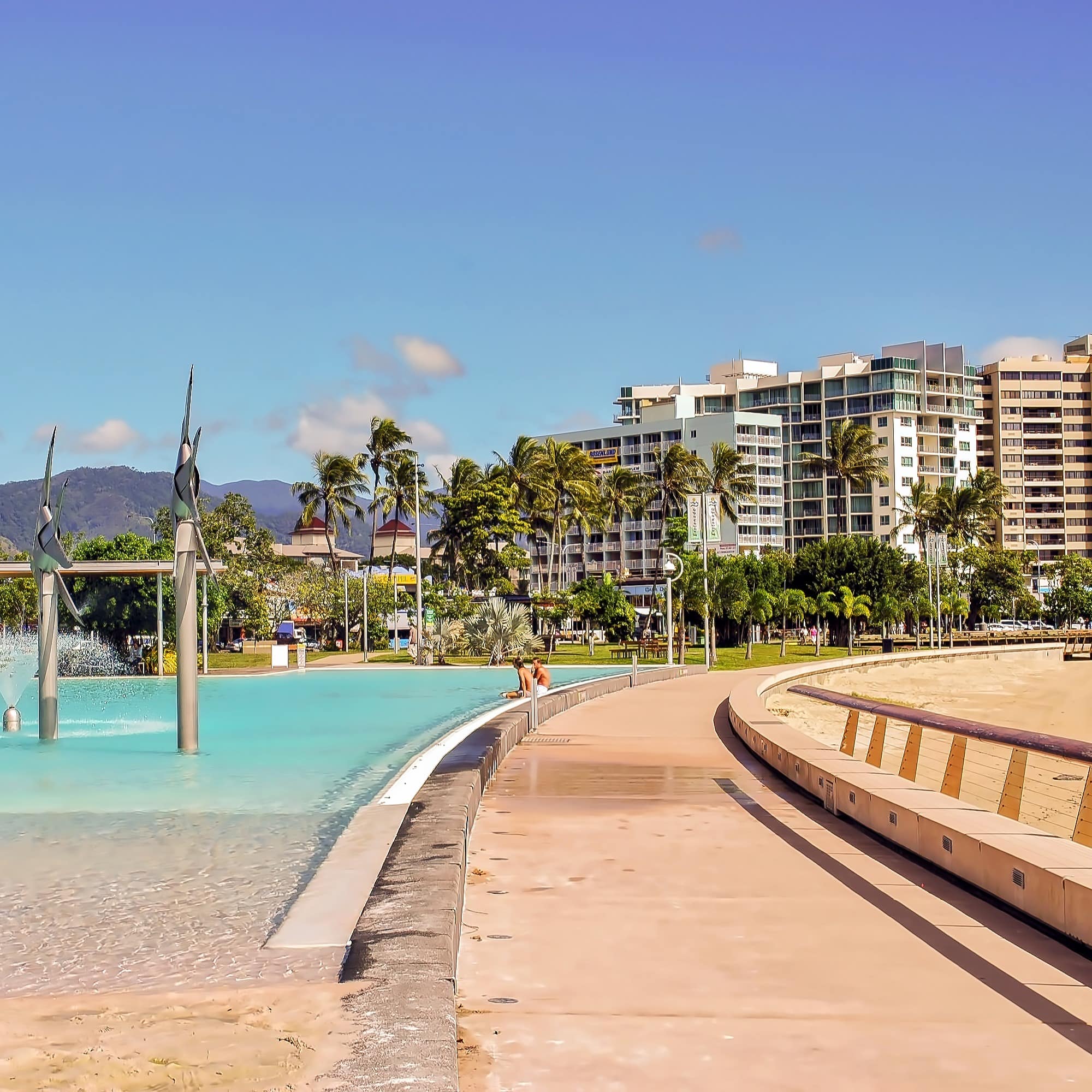 View of lagoon in front of city with boys sitting on wall
